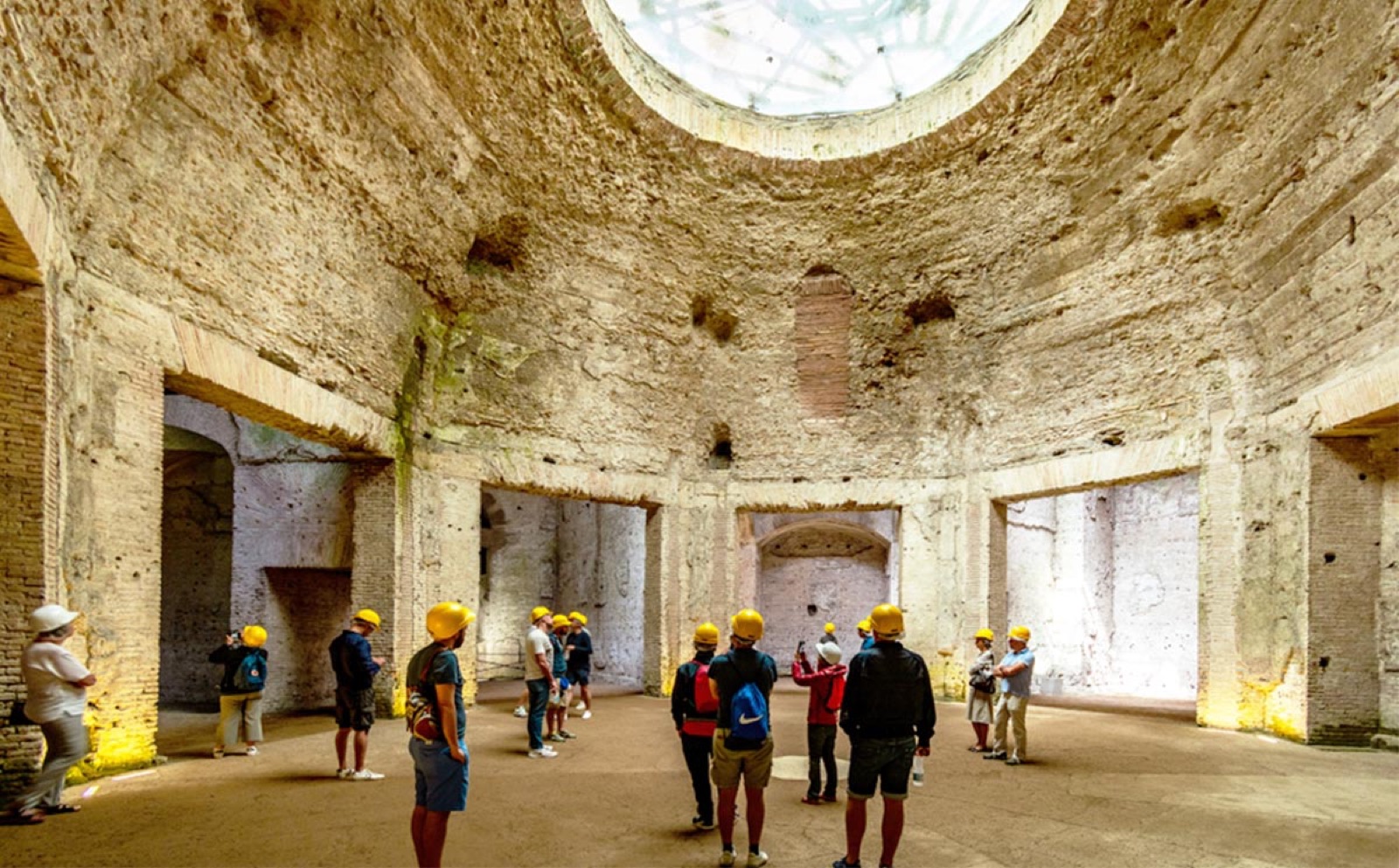 Sala Ottagona della Domus Aurea con visitatori in casco protettivo sotto l'oculo