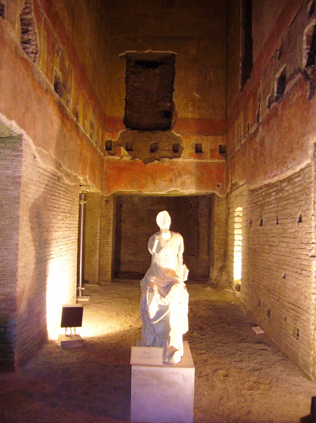 Statua di Musa illuminata in una sala affrescata della Domus Aurea